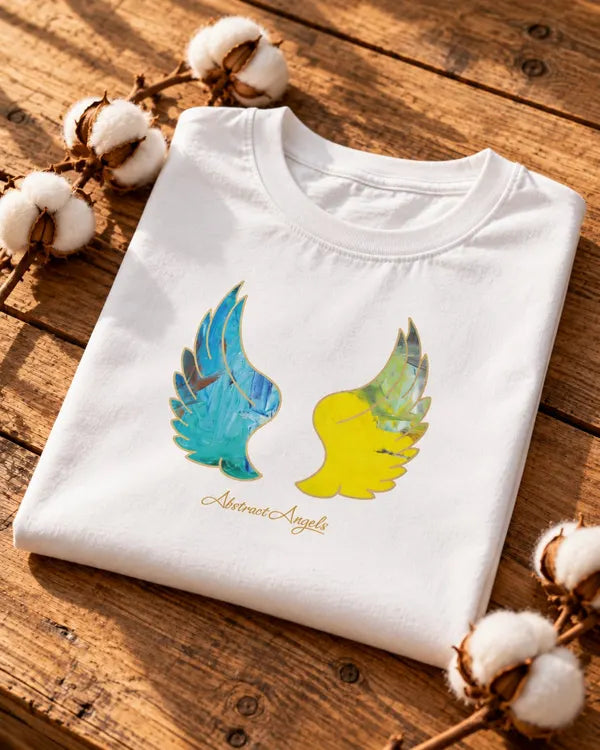 Organic cotton T-shirt with two angel wings artwork, folded on a wooden table