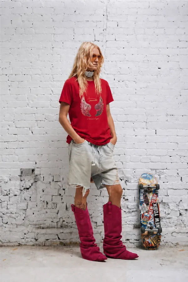 Red T-shirt styled with a skateboard against an urban wall
